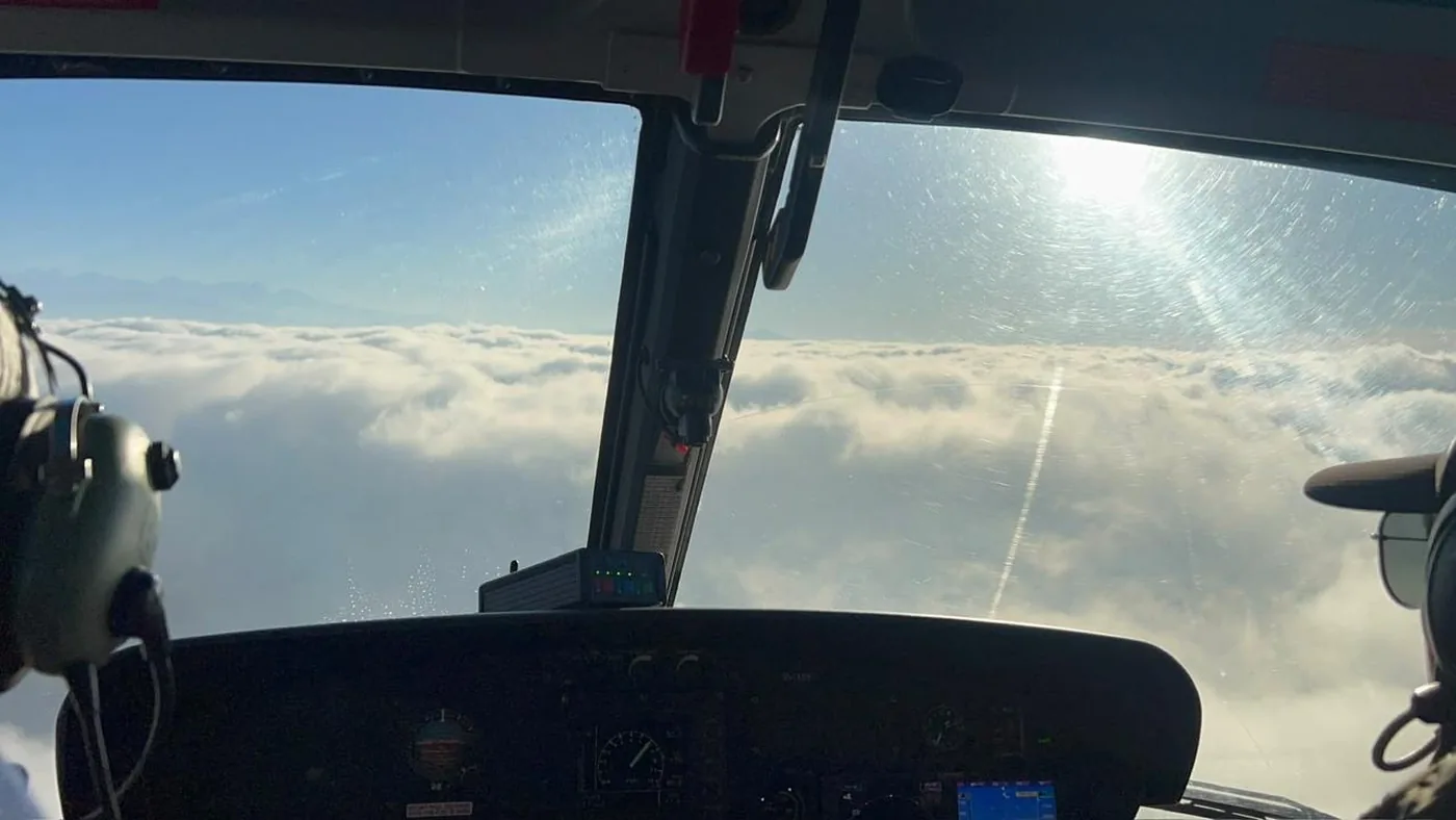 View from a helicopter cockpit above the cloud layer in Nepal